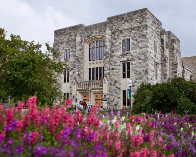Newman Library with flowers in the foreground in the early fall