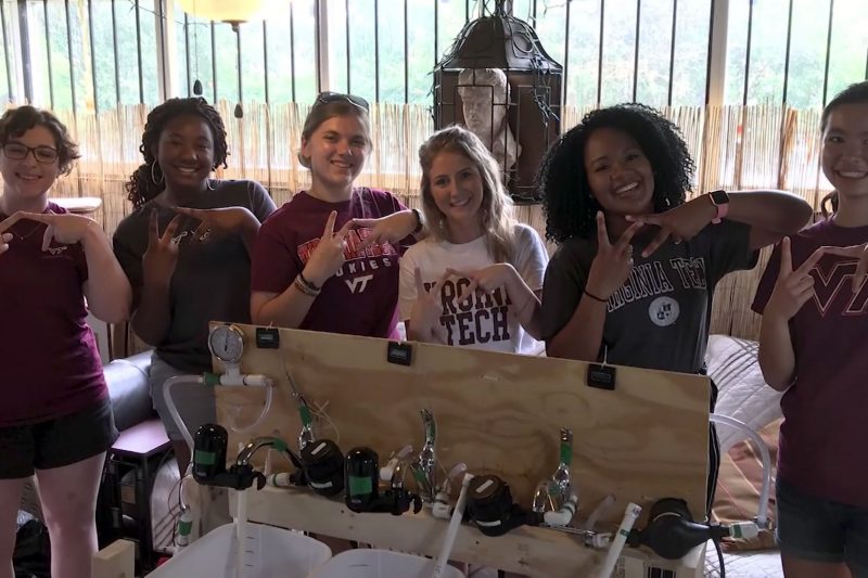 several female students of different ethnicities making the VT hand sign