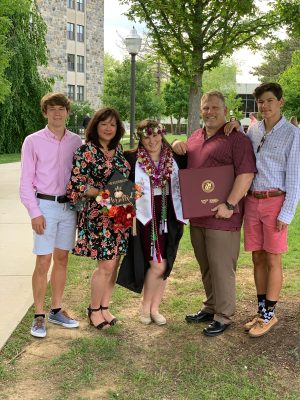 Sarah Preston posing with family at graduation. 