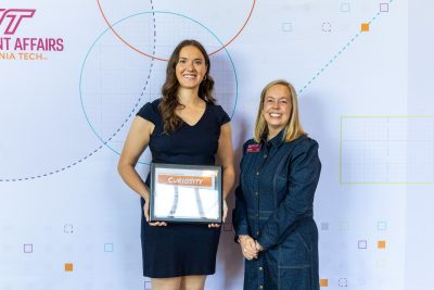 Two women posing with an award certificate.